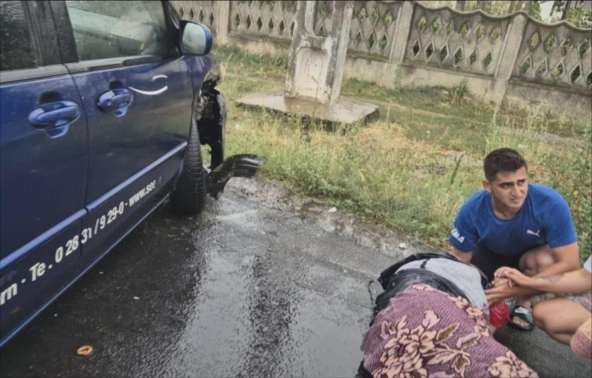 A volunteer kneeling beside the damaged car
