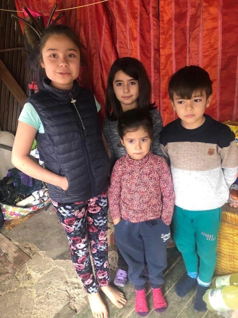Four siblings in Romania standing together at home