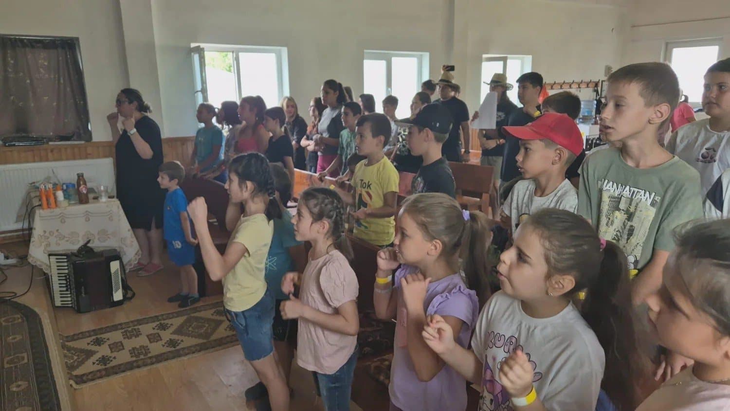 Children singing inside the small church in Balaci