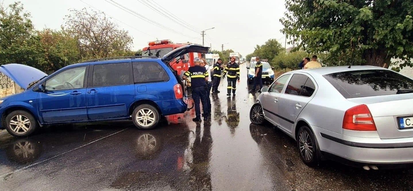 Two damaged cars on a wet road after the accident, with emergency crews nearby
